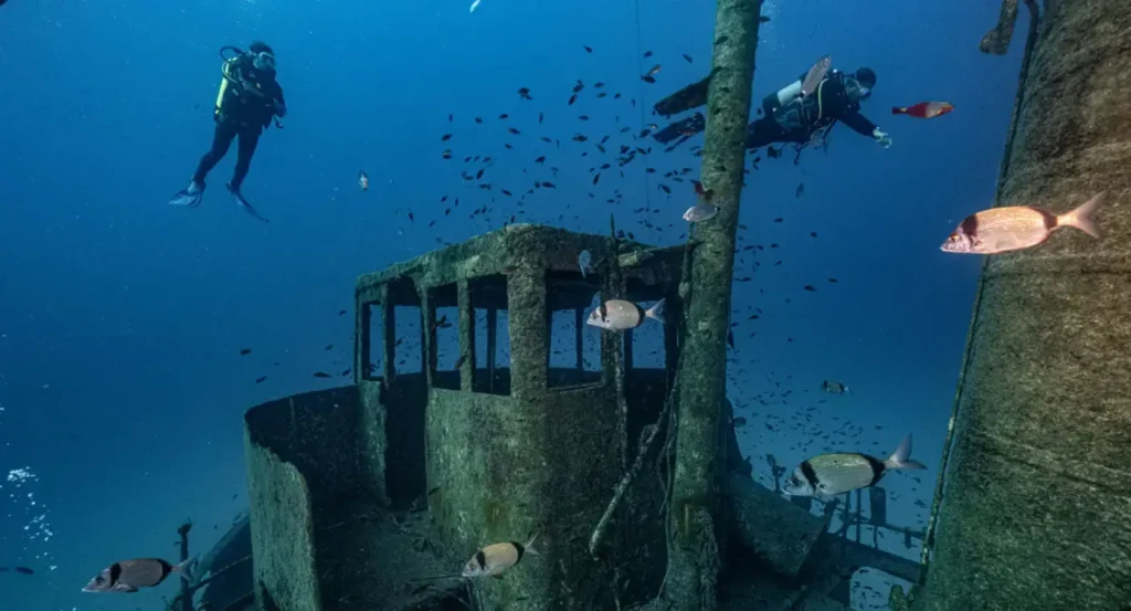 Certified divers exploring a large shipwreck on the advanced wreck diving course in Malta